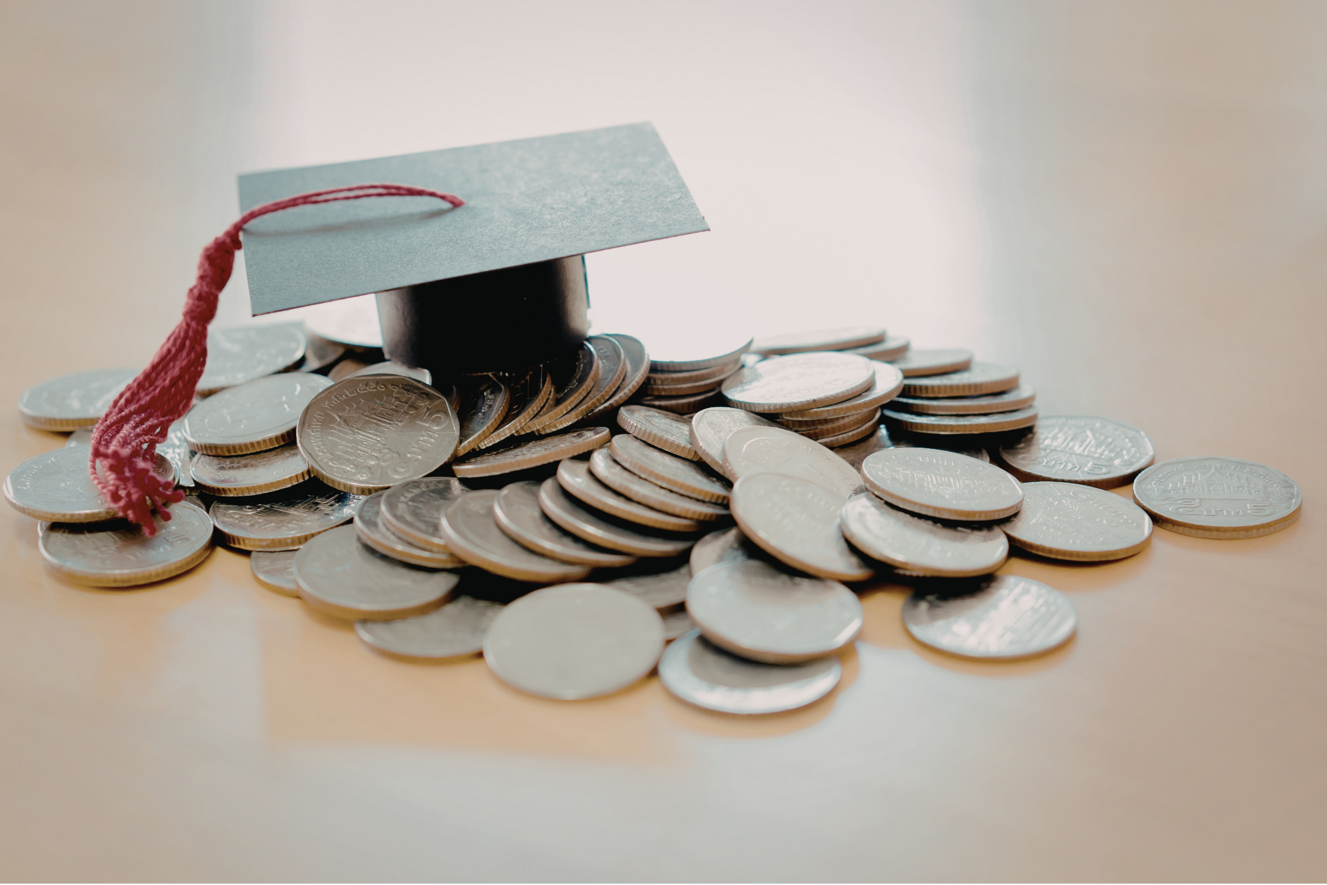 Graduation cap sitting on coins representing tuition options