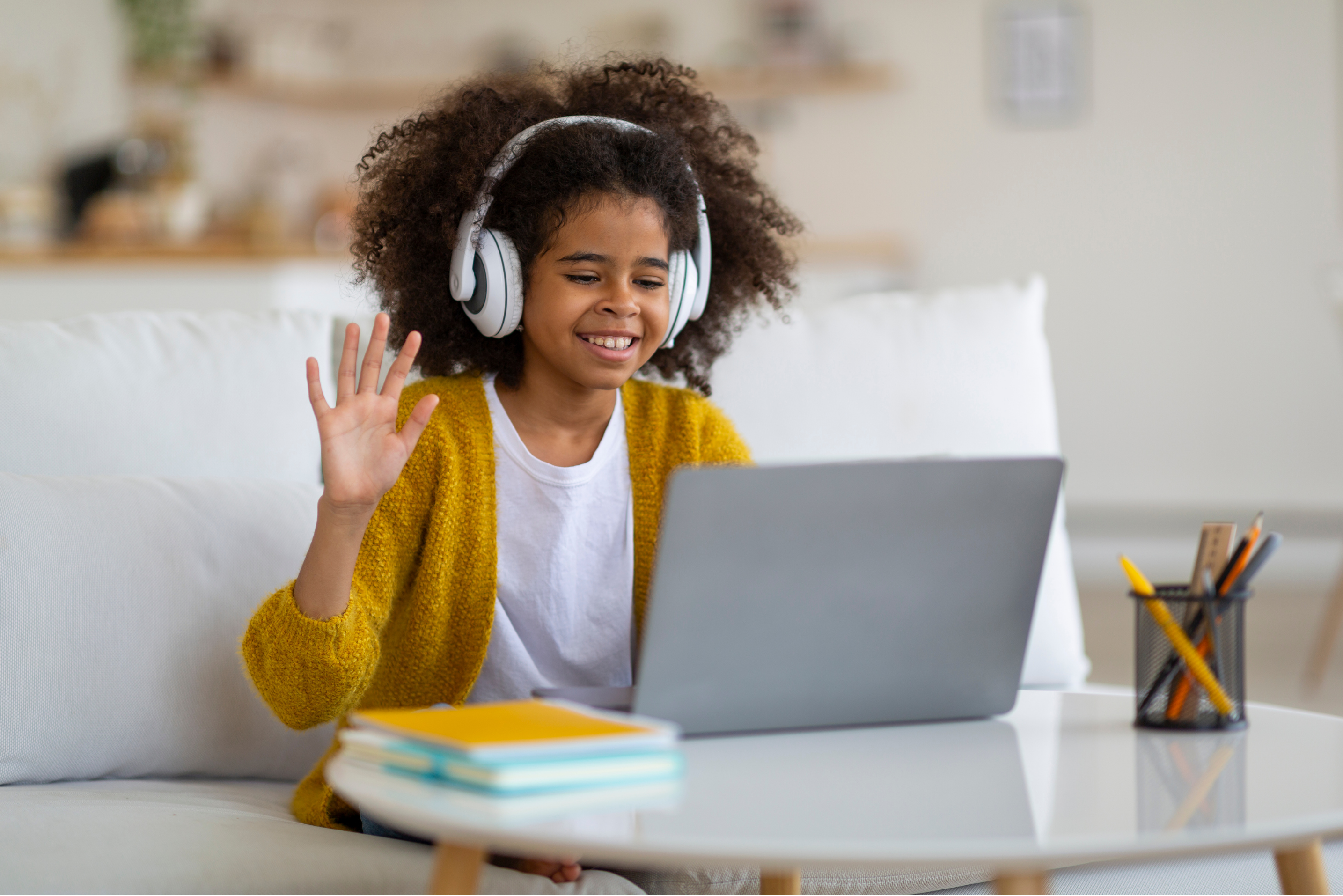 Smiling student with headphones using laptop