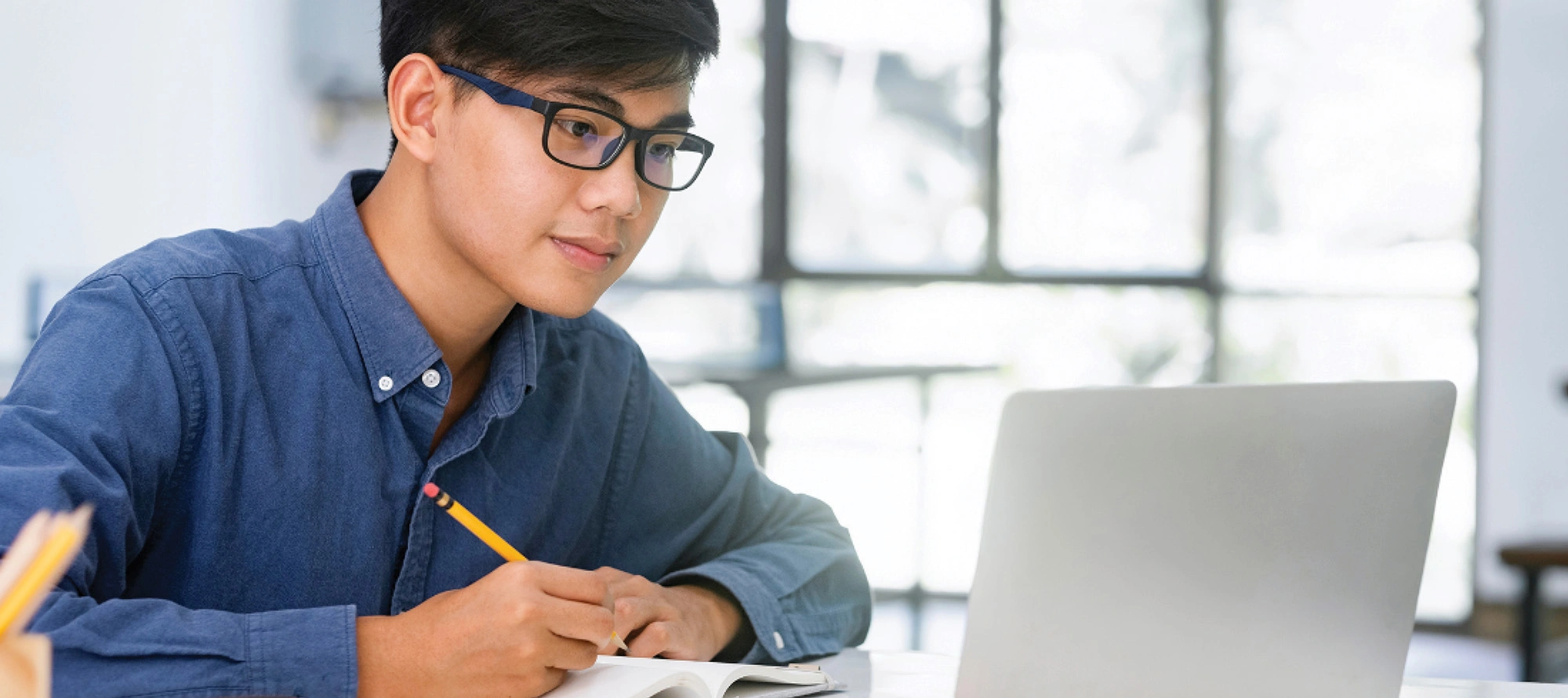 Student taking notes during an online class